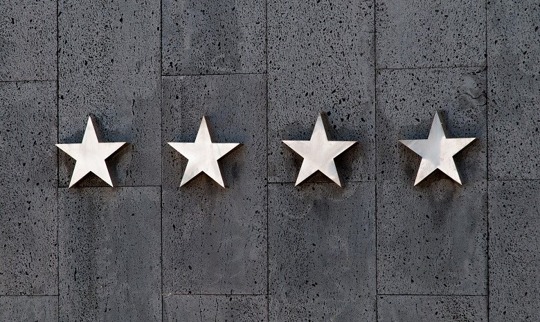 Textbroker Autorengremium 2019 Beitragsbild 2: Vier Sternsymbole an einer grauen Mauer